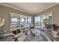 Bright living room featuring water views, modern furniture, and a sliding door to a private balcony at 1038 Bellasol Way # 202, Apollo Beach, FL 33572