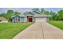 Charming single-story home with long driveway, well-kept lawn, and blue siding under a sunny sky at 12037 Conway St, Spring Hill, FL 34609
