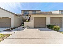 Charming townhome featuring a two-car garage, well-maintained landscaping, and a welcoming curb appeal at 1205 Hounds Run, Safety Harbor, FL 34695
