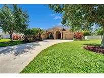 Charming single-story home with well-manicured lawn, mature trees, and a circular driveway at 12903 49Th E Ln, Parrish, FL 34219