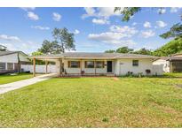 Charming single-story home features a well-maintained lawn, inviting curb appeal, and covered carport at 2001 Spooner Dr, Plant City, FL 33563
