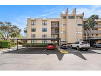 Condominium building featuring a covered parking area and well-maintained landscaping at 2614 Cove Cay Dr # 301, Clearwater, FL 33760