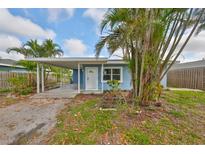 Charming blue home with a covered parking area and tropical landscaping at 3241 Williamsburg St, Sarasota, FL 34231