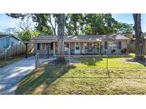 Charming single-story home with a covered front porch and a well-maintained lawn at 9616 Oak Ridge Ave, Riverview, FL 33578