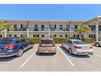 Multi-Gathering home with balconies, well-maintained landscaping and parking in front on a sunny day at 100 Glennes Ln # 207, Dunedin, FL 34698