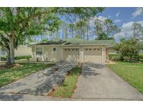 Charming villa with two-car garage, lush landscaping, and inviting curb appeal at 34833 Double Eagle Ct, Zephyrhills, FL 33541