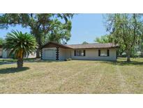 Charming single-story home with a well-maintained lawn and mature tree shading the property at 39696 Meadowood Loop, Zephyrhills, FL 33542