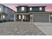 Inviting two-story home with a brick driveway and a two-car garage offers modern living at 4007 W Gray St, Tampa, FL 33609