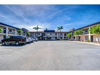 Wide view of the condo complex parking lot with palm trees providing shade and ample parking for residents and guests at 10190 Imperial Point W Dr # 8, Largo, FL 33774