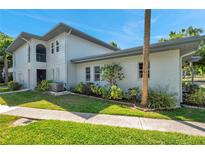Corner unit condominium featuring a two-story building with well-maintained landscaping and an inviting entrance at 10800 Us Highway 19 N # 128, Pinellas Park, FL 33782