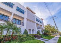 Elegant building featuring balconies, arched entryways, and beautiful landscaping at 216 S Audubon Ave, Tampa, FL 33609
