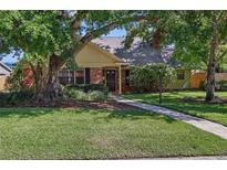 Charming single-story home with a well-manicured lawn, lush trees, and a brick pathway to the front door at 2809 Kimberly Lane Ln, Tampa, FL 33618