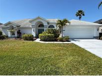 Charming single-story home with well-manicured lawn, lush landscaping and a two car garage on a sunny day at 4228 Presidential Avenue E Cir, Bradenton, FL 34203
