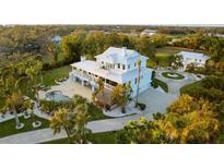 Expansive estate featuring a luxurious pool, tiki bar, circular driveway, and pristine landscaping at 450 Bayshore Dr, Terra Ceia, FL 34250