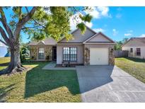 Charming single-story home featuring stone accents, a well-manicured lawn, and an attached two-car garage at 5650 25Th Street E Cir, Bradenton, FL 34203