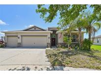 Charming single-story home featuring a well-manicured lawn, a three-car garage, and inviting curb appeal at 627 Washita Stone Dr, Ruskin, FL 33570