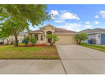 Charming single-story home featuring a well-manicured lawn and mature landscaping at 10718 Standing Stone Dr, Wimauma, FL 33598