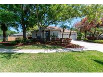 Charming single-story home with mature trees, lush landscaping, and a well-maintained lawn at 11704 Derbyshire Dr, Tampa, FL 33626