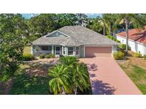 Charming single-story home with a well-maintained lawn, mature landscaping, and a two-car garage at 1402 Bluewater Dr, Sun City Center, FL 33573