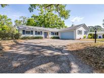 Charming single-story home boasts a large driveway and a well-maintained front yard with mature trees at 2244 Glenmoor N Rd, Clearwater, FL 33764