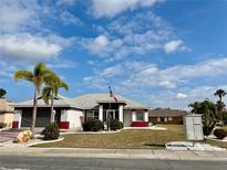 Charming single-story home featuring well-maintained landscaping and an American flag at 301 Caloosa Palms Ct, Sun City Center, FL 33573