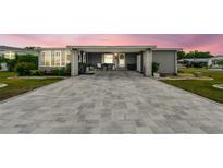 Charming single-story home with gray siding, manicured landscaping, and an extended paved driveway at 37510 New Horizons Blvd, Zephyrhills, FL 33541