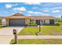 Charming single-story home with a stone-accented facade, well-manicured lawn, and inviting curb appeal at 7428 Bramblewood Dr, Port Richey, FL 34668