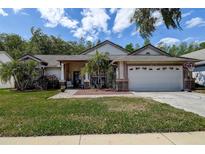 Charming single-story home with a two-car garage, landscaped yard, and inviting front porch at 7850 Lake Placid Ln, New Port Richey, FL 34655