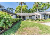Charming single-story home with lush green lawn and mature tropical landscaping at 90 S Highland Ave # 6, Tarpon Springs, FL 34689