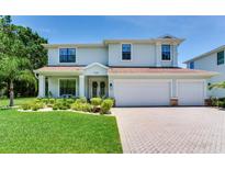 Beautiful two-story home with a well-manicured lawn, large garage and brick driveway at 13008 Eagles Entry Dr, Odessa, FL 33556