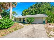 Charming single-story home featuring a well-maintained lawn and a one-car garage at 1424 Castleworks Ln, Tarpon Springs, FL 34689
