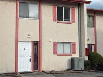 Beige and tan exterior of a two-story condo with coral trim and a white front door at 1610 58Th S Ave # 6, St Petersburg, FL 33712