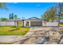 Charming single-story home featuring a well-maintained lawn and a two-car garage on a sunny day at 2217 Stacy Ct, Dunedin, FL 34698