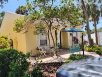 Charming yellow home with a brick-paved patio, seating, and a blue umbrella at 2512 W Texas Ave # C, Tampa, FL 33629