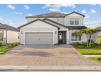 Charming two-story home featuring a two-car garage and a beautifully paved driveway at 2577 Buckthorn Loop, North Port, FL 34289
