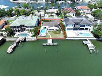 Stunning waterfront home with a private pool and dock, surrounded by lush landscaping and beautiful bay views at 5110 W Poe Ave, Tampa, FL 33629