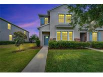 Inviting townhome featuring tidy landscaping, stone accents, and a charming blue front door at 6325 Shore Vista Pl, Apollo Beach, FL 33572