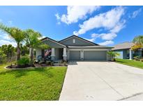 Charming single-story home featuring a two-car garage, lush lawn, beautiful landscaping, and a welcoming front porch at 6416 Cobble Bliss St, Zephyrhills, FL 33541