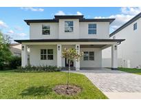 Stunning two-story home boasts a brick facade, covered porch, and manicured lawn at 806 W Adalee St, Tampa, FL 33603