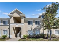 Exterior of a two-story condo in a community featuring multiple windows and neutral color palette at 9516 Amberdale Ct # 202, Riverview, FL 33569