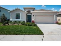 Charming single-Gathering home boasts lush landscaping, a two-car garage, and a covered entryway at 12315 Dora Trail, Parrish, FL 34219
