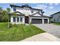 Beautiful two-story home with well-manicured lawn and three-car garage at 12409 Gentle Swan Pl, Odessa, FL 33556