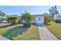 Charming home featuring lush landscaping, green grass, and an inviting entrance at 2202 Clubhouse Dr # 174, Sun City Center, FL 33573