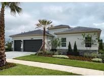 Beautiful single-story home featuring a manicured lawn and a two-car garage at 32212 Mahogany Valley Dr, Wesley Chapel, FL 33543