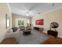 Bright living room with a large arched window, hardwood floors, and cozy neutral-toned furniture at 4207 S Dale Mabry Hwy # 3302, Tampa, FL 33611