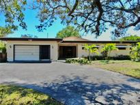 Charming single-story home with a well-maintained front yard and mature trees providing shade at 500 Oleander S Way, St Petersburg, FL 33707