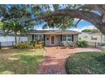 Charming single-story home with brick walkway, mature trees, and a well-maintained front yard at 712 43Rd N Ave, St Petersburg, FL 33703