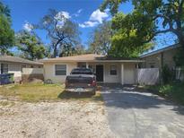 Modest single-story home featuring a cozy design, complemented by a truck parked in the driveway at 8609 N 11Th St, Tampa, FL 33604