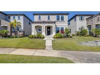 Charming two-story home featuring a well-manicured lawn and inviting front entrance, flanked by lush landscaping at 13319 Dorado Shores Ave, Riverview, FL 33579