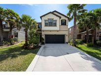 Charming two-story home with a well-manicured lawn and mature palm trees on a bright, sunny day at 1626 Tallulah Ter, Wesley Chapel, FL 33543